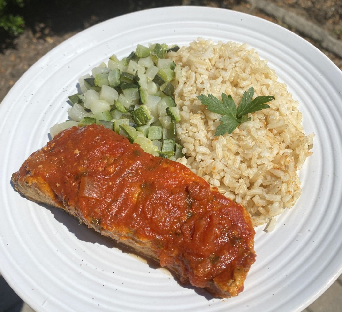 Barramundi con tomate y hierbas, arroz y calabacín